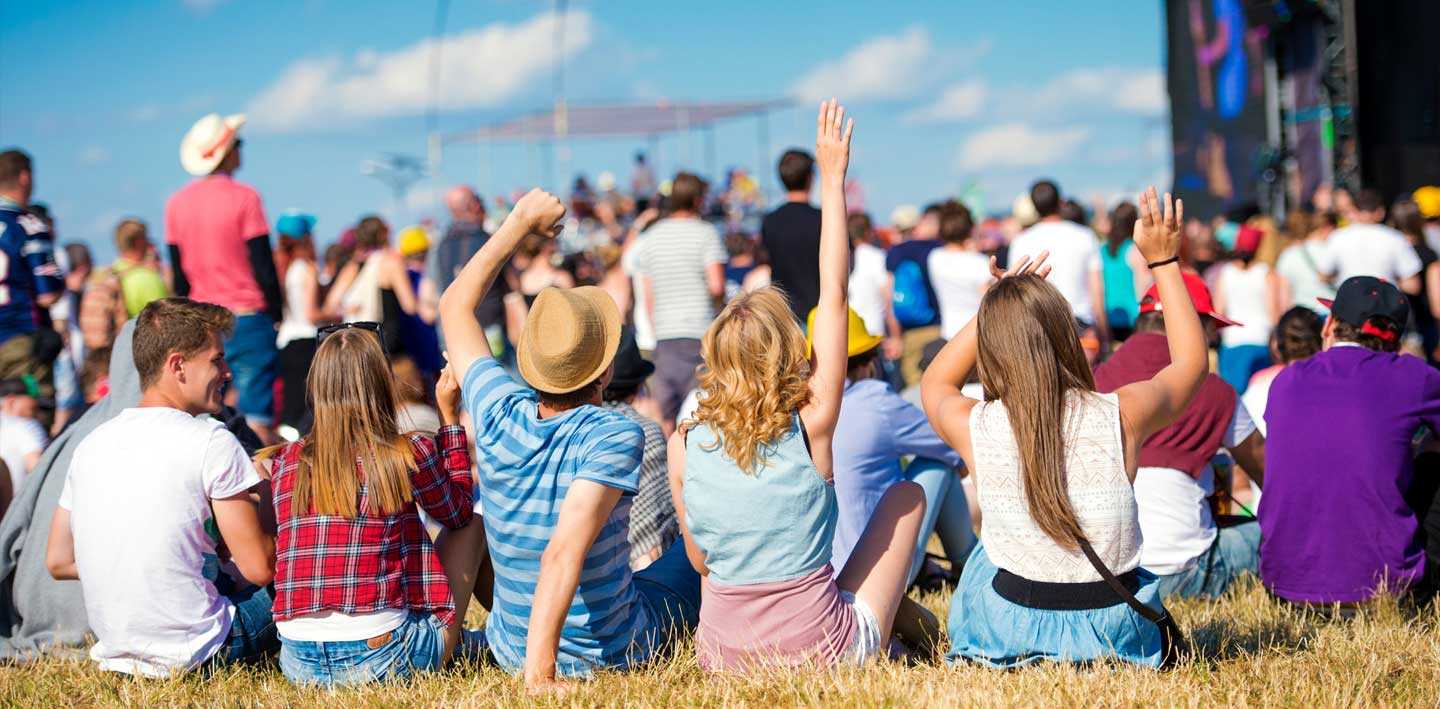 Photo of young people sitting outside at a festival